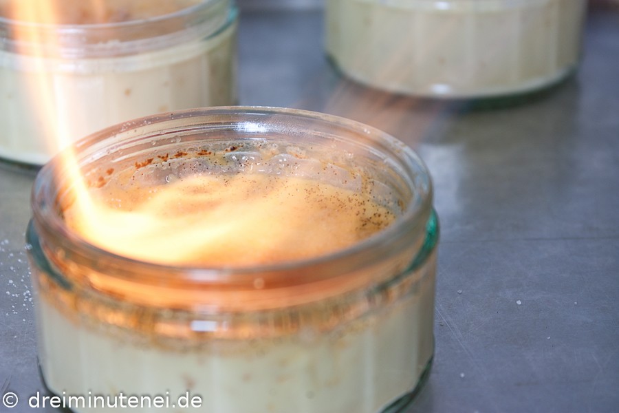 Creme Brulee beim Karamellisieren Creme Brulee beim Karamellisieren